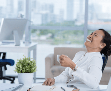 A woman happily having her tea in office