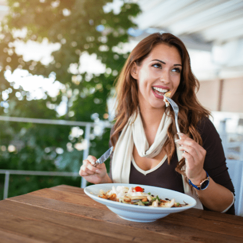 A woman eating salad with a fork