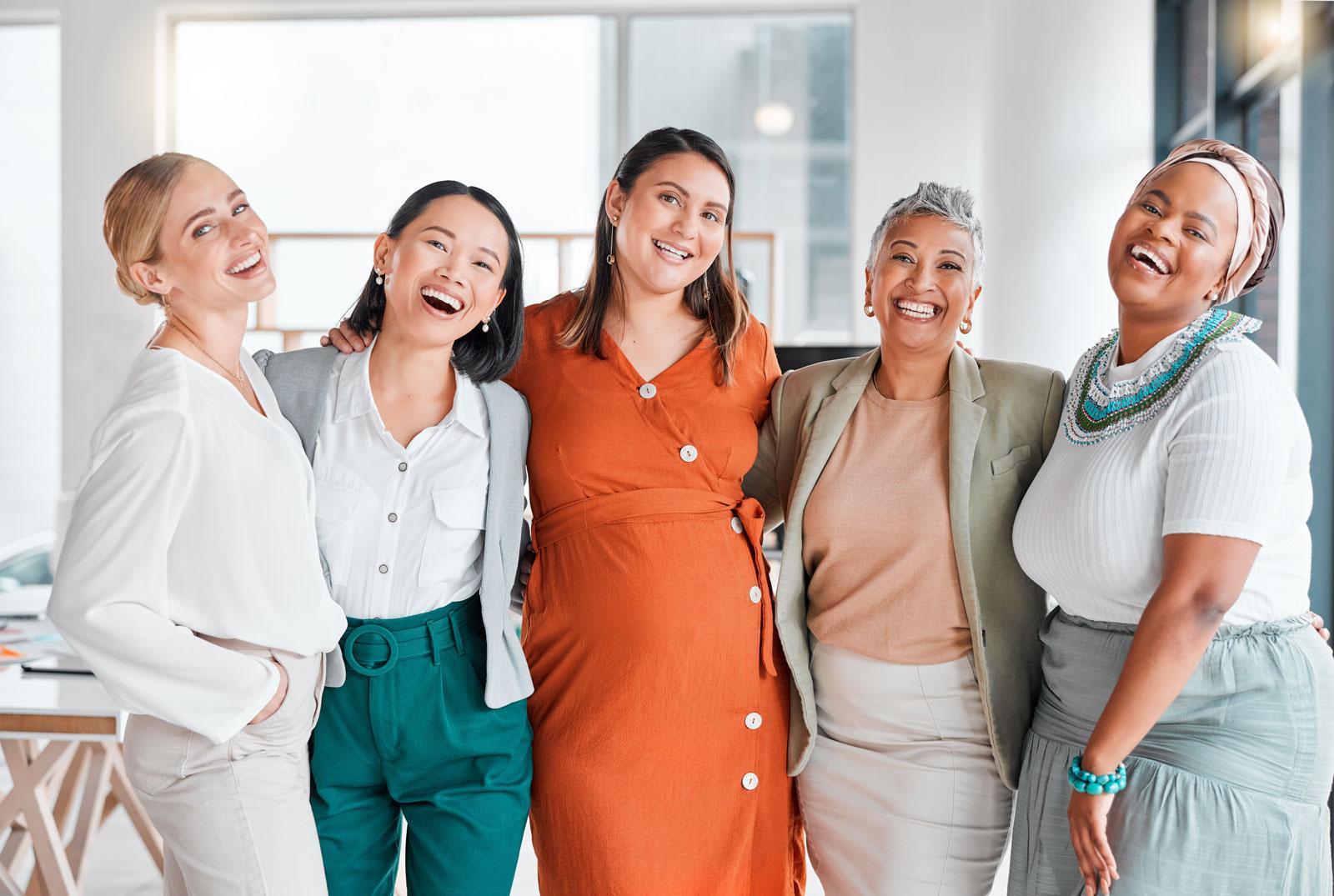 A team of five working women smiling