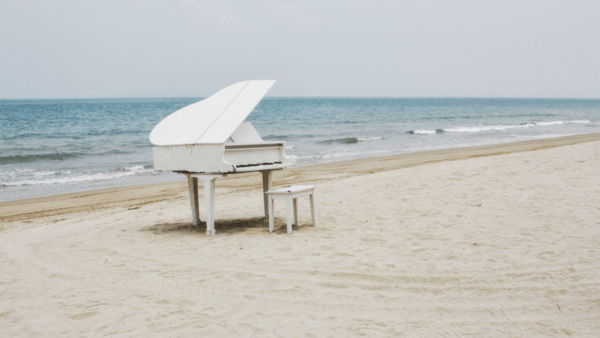 A piano with a bench on sea side